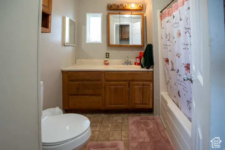 Bathroom featuring a wood-finish vanity with an integrated sink, a built-in medicine cabinet, and a window