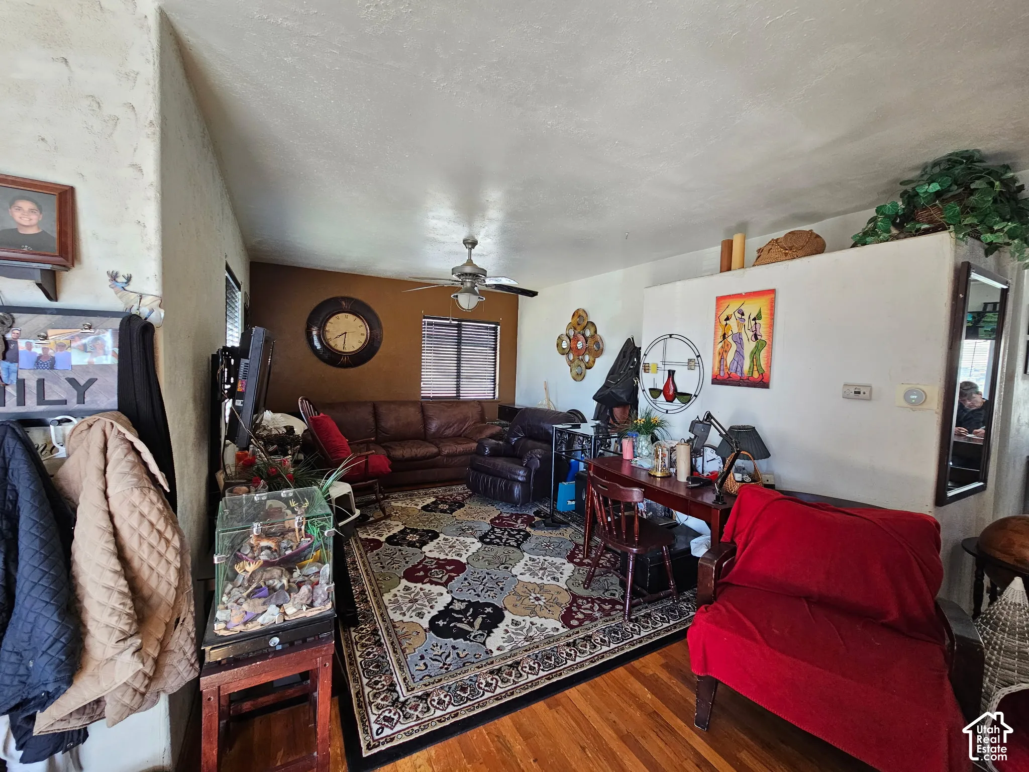 Wood-finish flooring with a textured ceiling and a ceiling fan