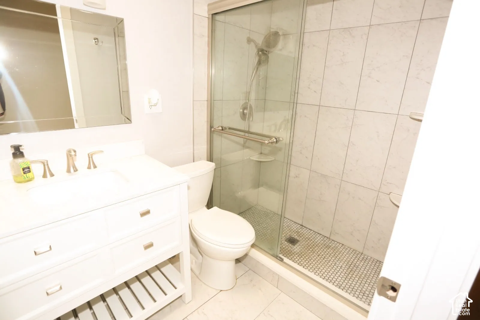 White vanity with brushed gold hardware and an undermount sink