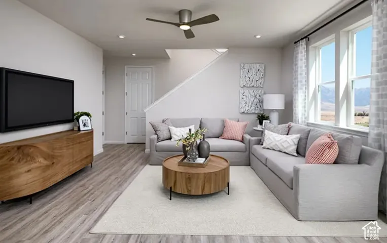 Recessed lighting, wood-finish flooring, ceiling fan, and large windows with mountain scenery