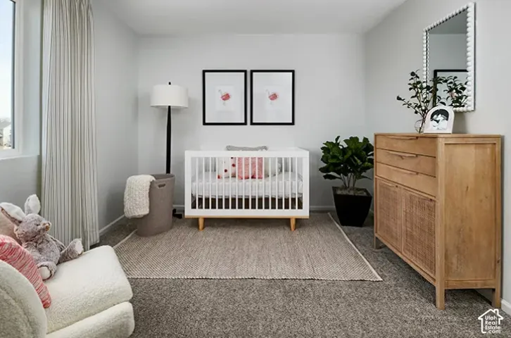 Neutral wall color, window with vertical striped drapes, textured carpeting, and a light wood-finish dresser with woven paneling