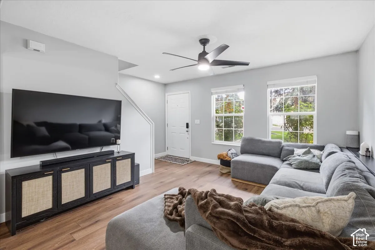 Wood-finish flooring, white trim, recessed lighting, and a ceiling fan with light fixture