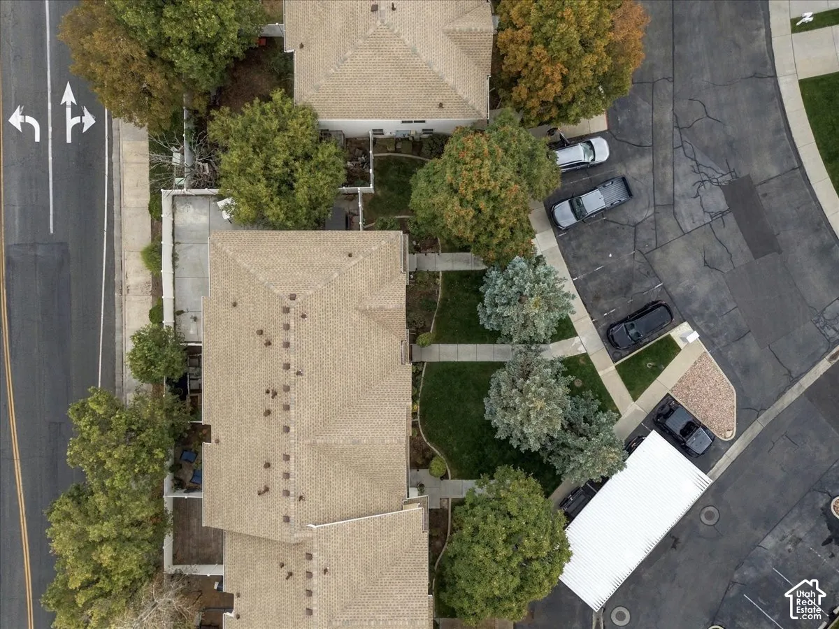 Pitched roofs, mature trees, manicured lawns, paved parking, and a covered parking structure