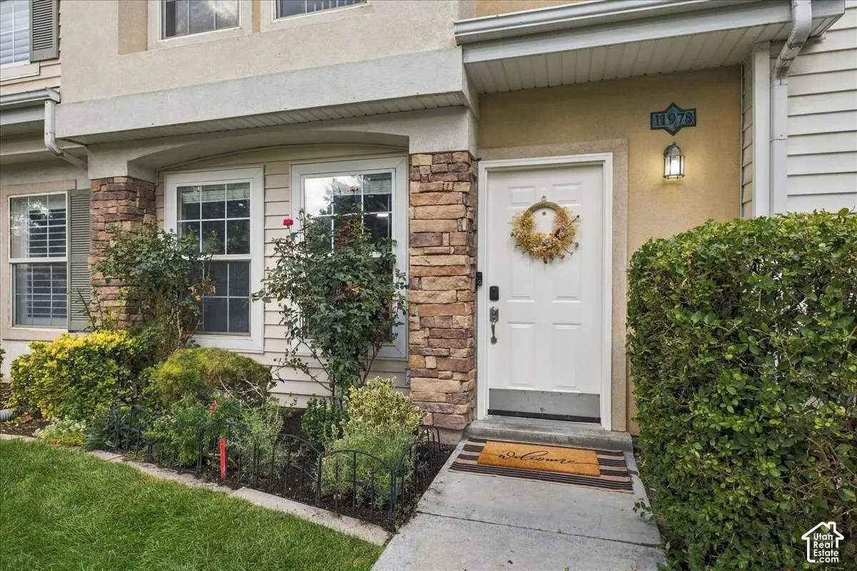 Inviting entry featuring a white panel door, stone fa