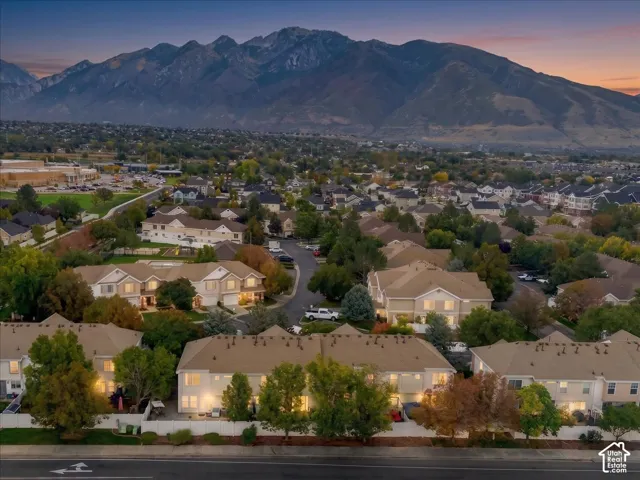 Mountain backdrop, residential area, multiple multi-story buildings, mature trees, paved roadways