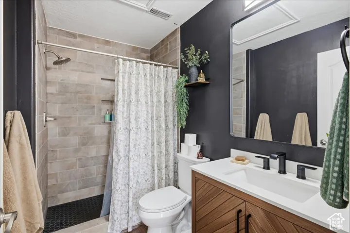 Bathroom featuring a vanity with wood-finish cabinetry, a white countertop, and matte black fixtures