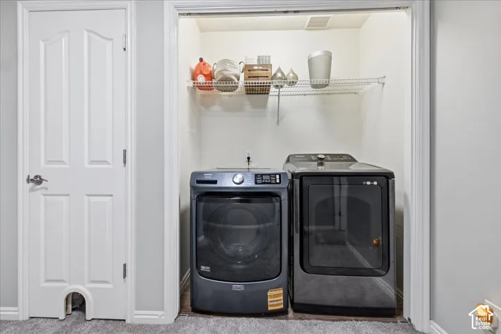 Laundry closet featuring a wire shelf and wood-finish flooring