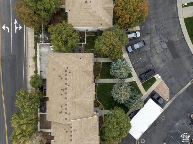 Pitched roofs, mature trees, manicured lawns, paved parking, and a covered parking structure