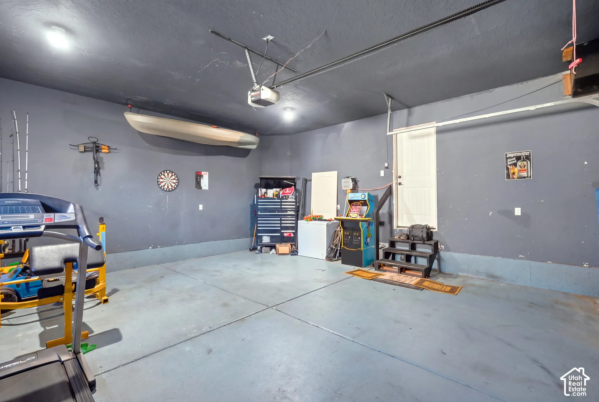 Spacious garage area featuring a concrete floor, painted walls, and overhead lighting