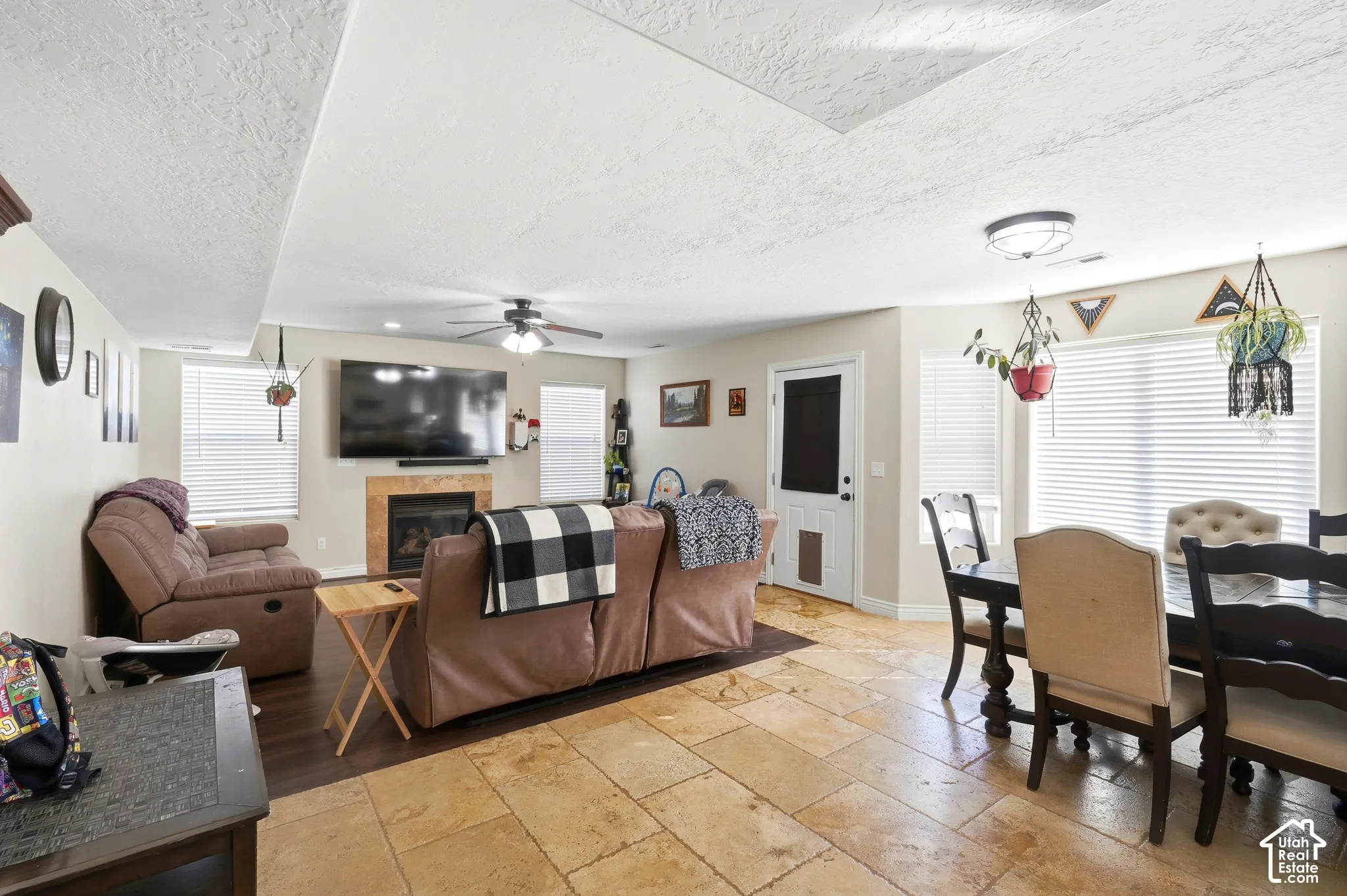 Integrated living space featuring a fireplace with a stone surround, recessed ceiling, wood-finish flooring, and tile flooring