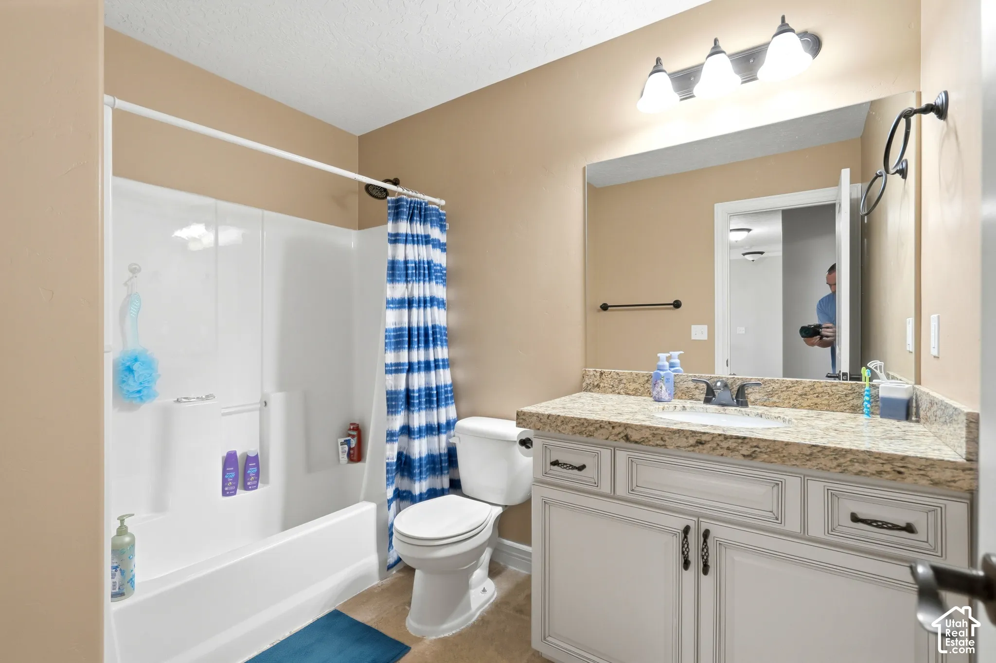 White vanity with bronze hardware, granite-style countertop, and integrated sink