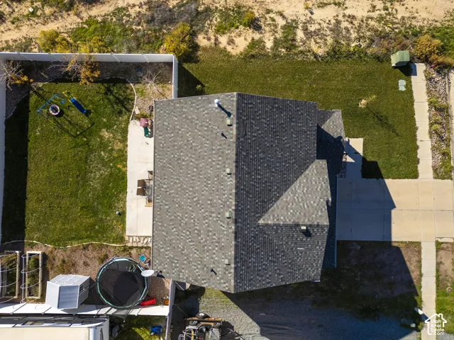 Asphalt shingle roofing, concrete driveway, concrete pathway, and landscaped yard