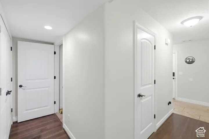 Recessed lighting, wood-finish flooring, white paneled doors, black door hardware, ceiling-mounted light fixture