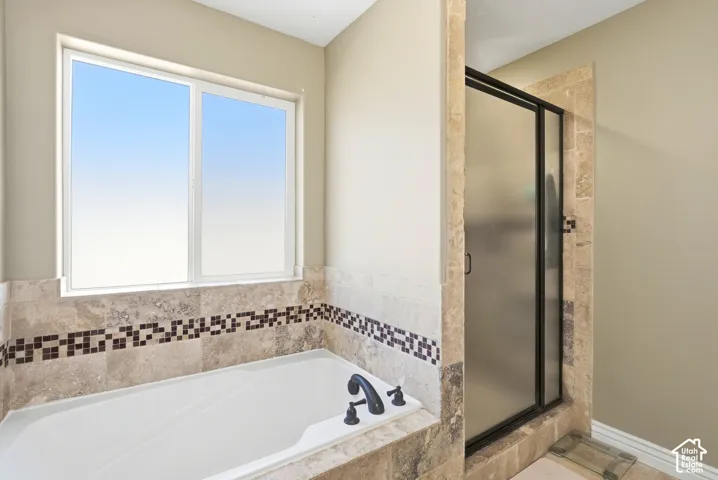 Built-in bathtub with a tile surround and mosaic accent