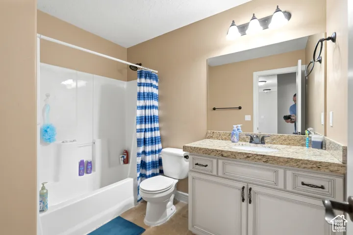 White vanity with bronze hardware, granite-style countertop, and integrated sink