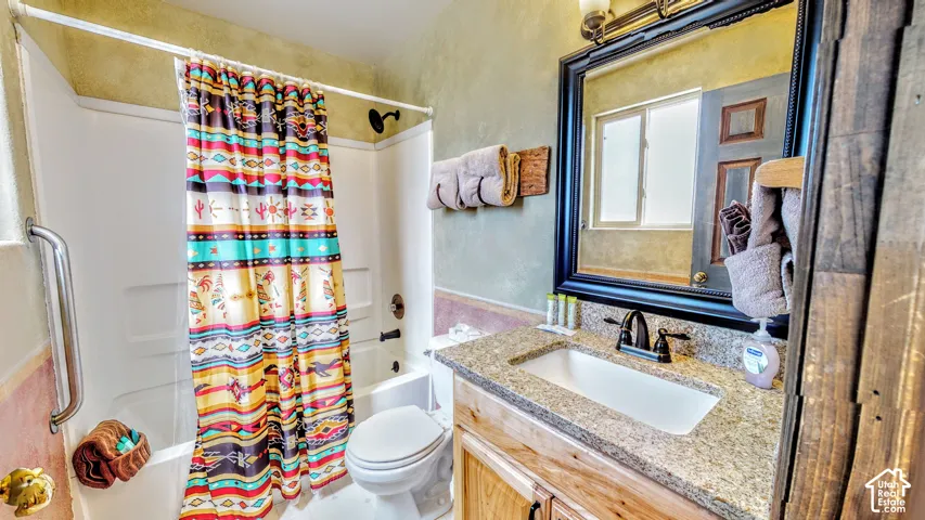 Granite-style countertop with undermount sink, dark bronze-finish faucet, and wood-finish vanity