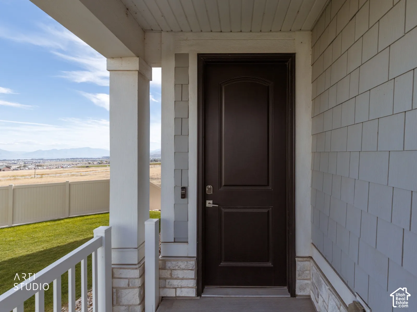 Entry door with a dark finish, flanked by siding with a shingle-style texture