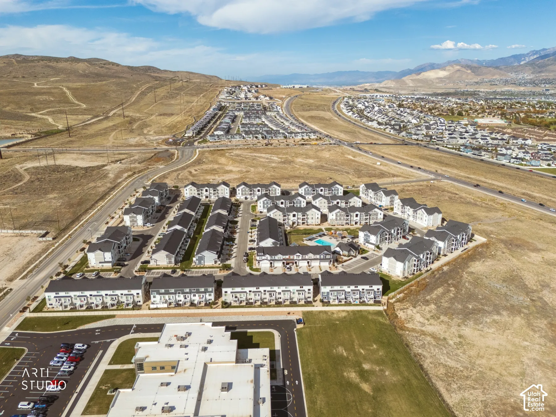 Contemporary residential development featuring a community pool and paved roadways