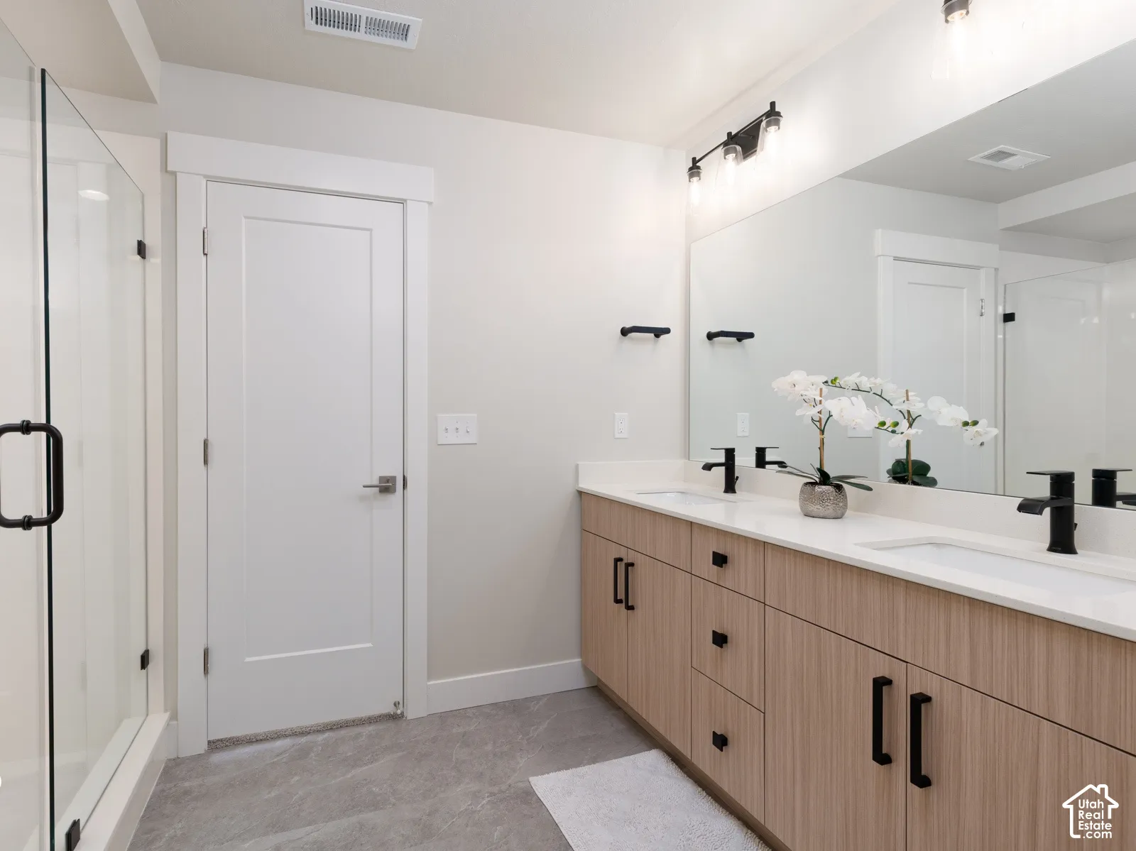 Dual vanity with wood-finish cabinetry and white countertops