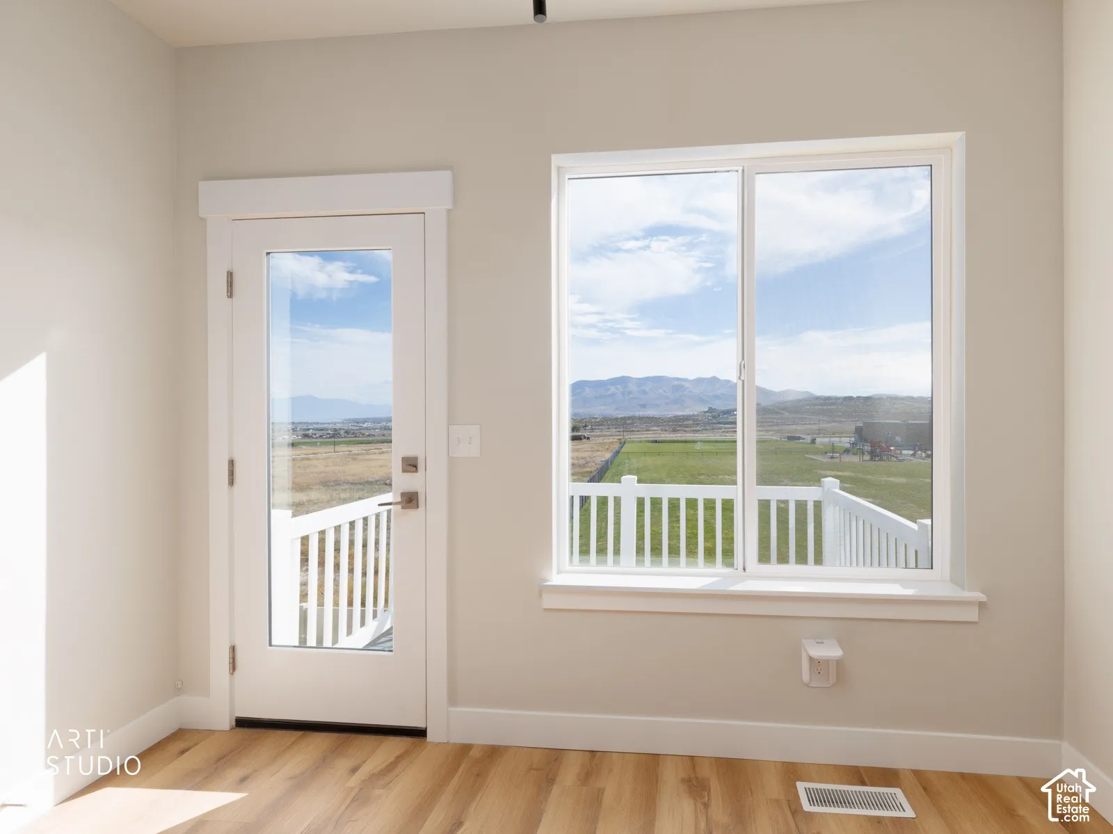 Wood-finish flooring, white trim, and a full-light exterior door