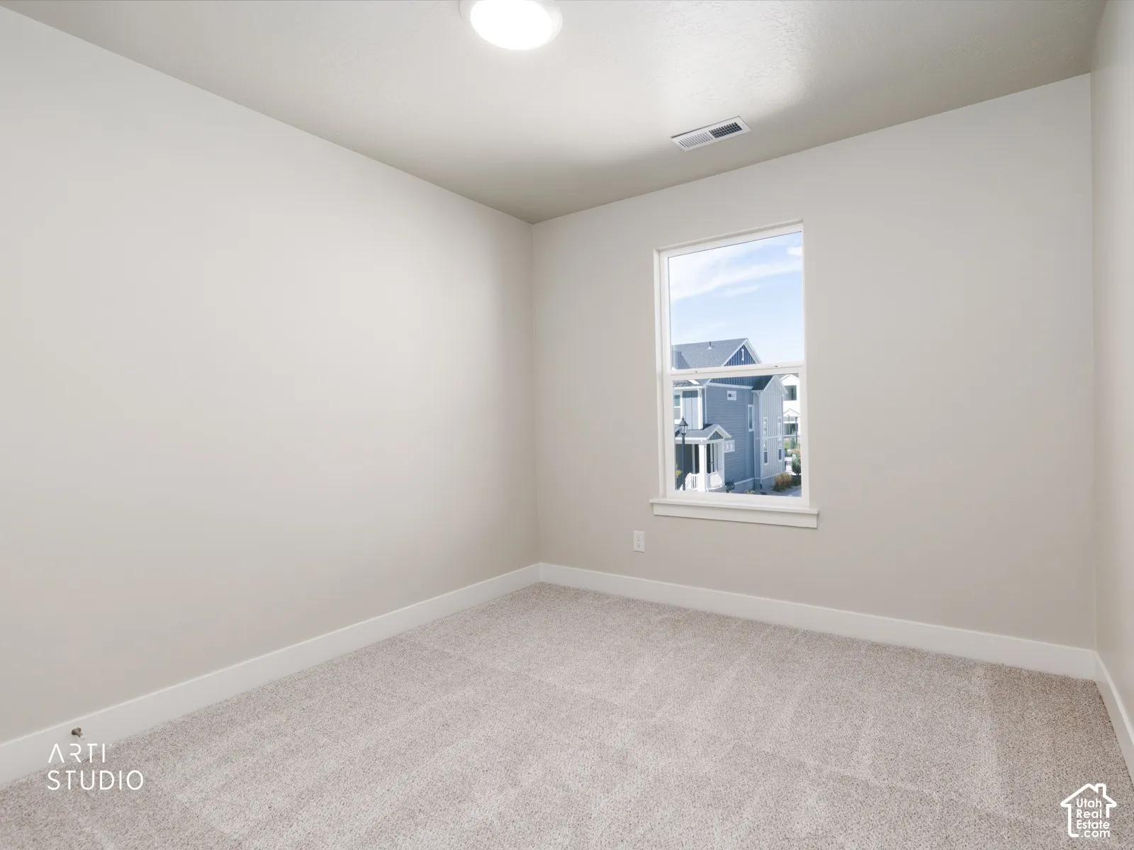 Light-toned walls, neutral carpeting, and a single window with white trim