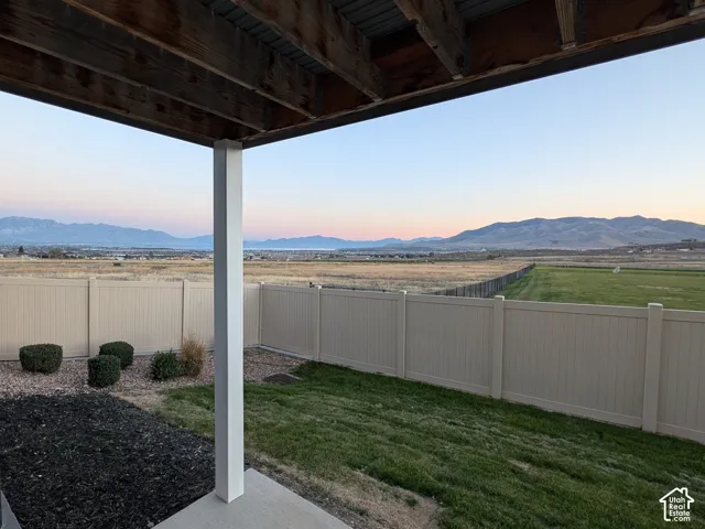 Covered patio with concrete flooring, framed by a white post