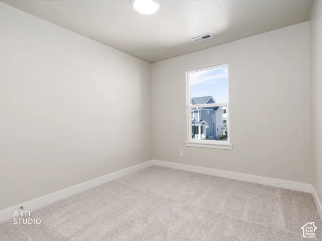 Light-toned walls, neutral carpeting, and a single window with white trim