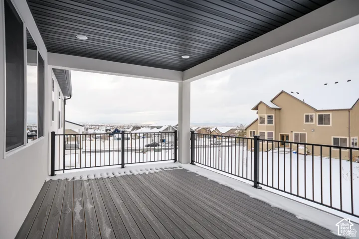 Covered outdoor deck with composite decking, recessed lighting, and black metal railings