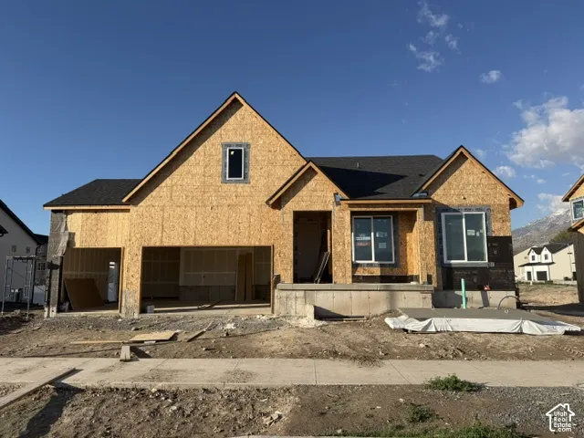 New construction residence featuring an expansive garage, steep roof gables, asphalt shingle roofing, energy-efficient windows, and a concrete foundation
