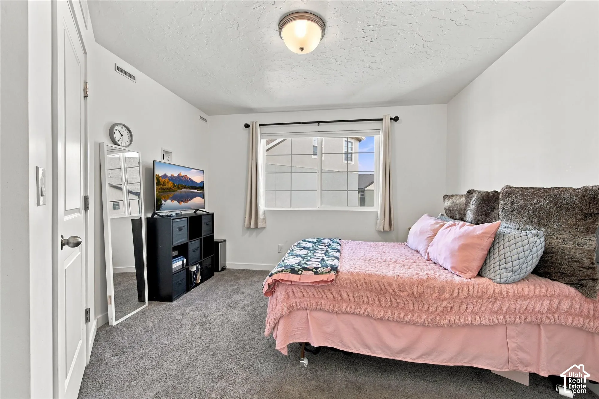 White walls, neutral carpeting, and a window with white trim
