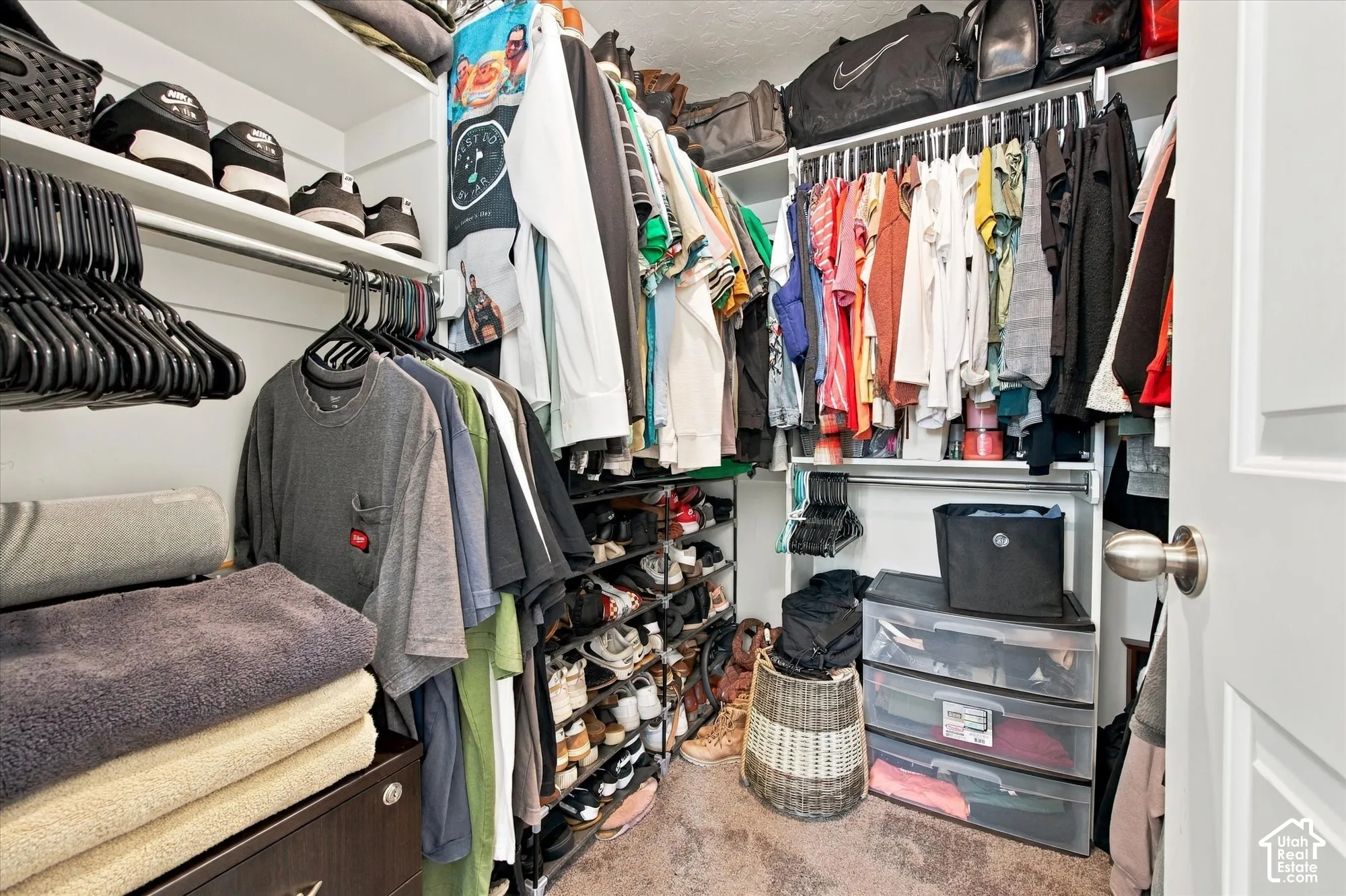 Custom closet system featuring multiple hanging rods, integrated shelving, and carpet flooring