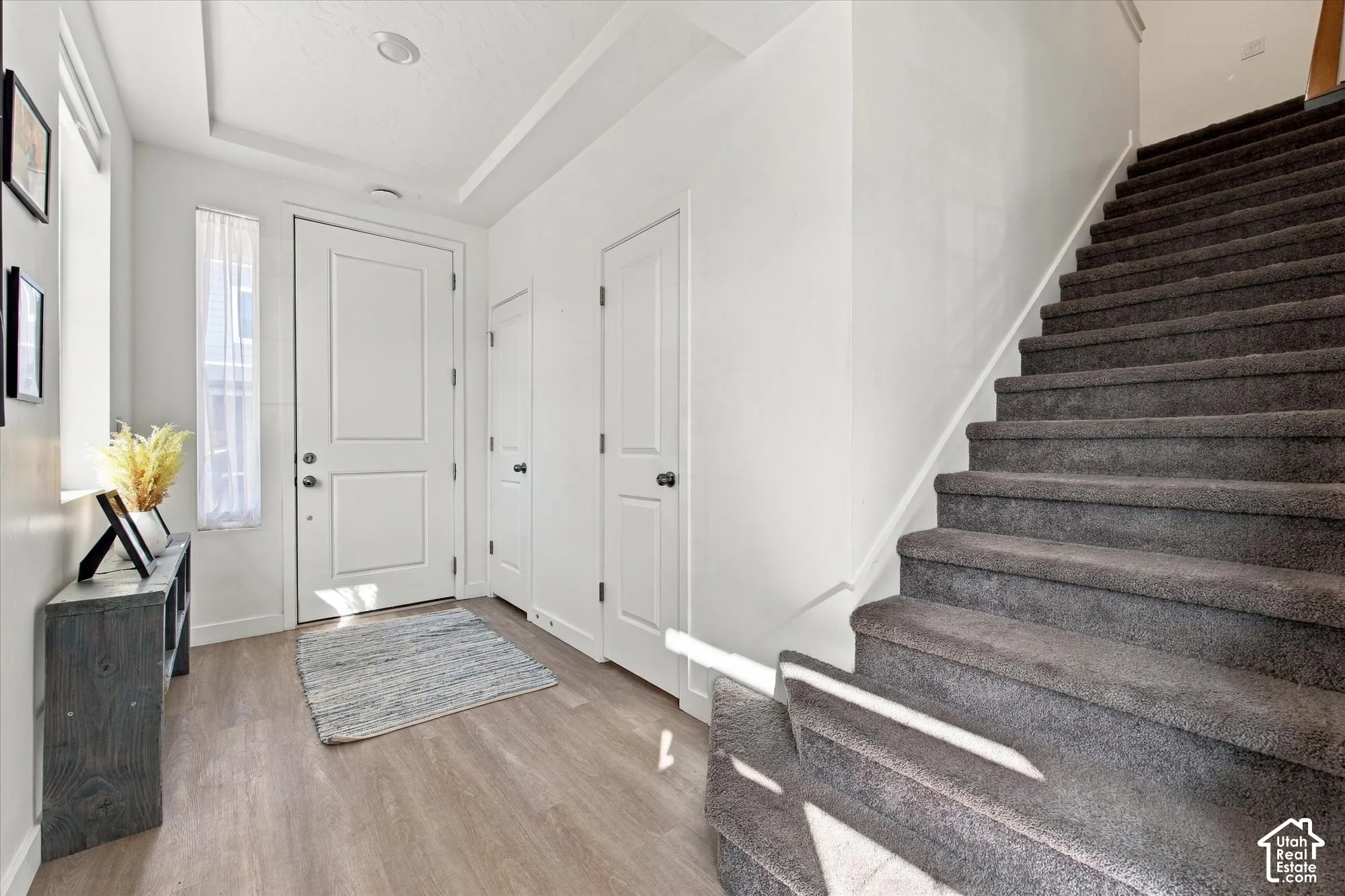 Entryway featuring light wood-finish flooring, a white paneled door, and recessed lighting