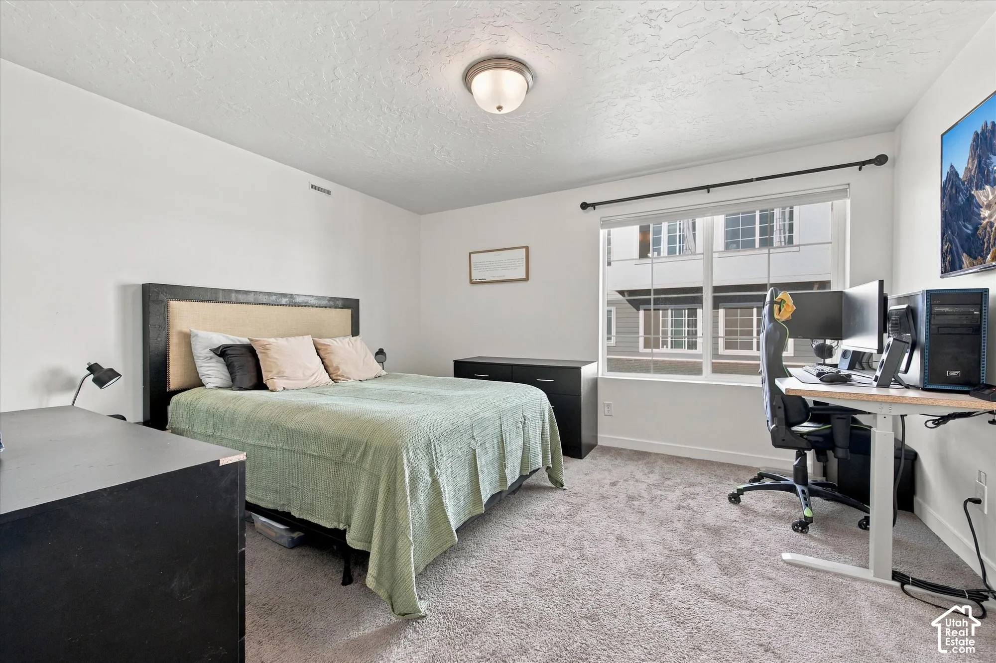 Recessed ceiling light fixture, large window with roller shade, carpeted flooring, and neutral wall tones