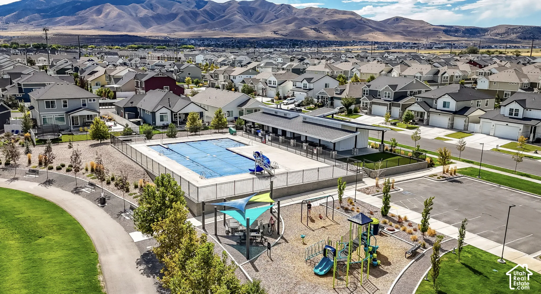 Community amenities featuring an outdoor swimming pool, shaded playground area, paved walking paths, and landscaped common areas