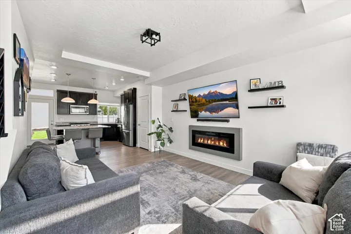 Living area featuring an electric fireplace and wood-finish flooring