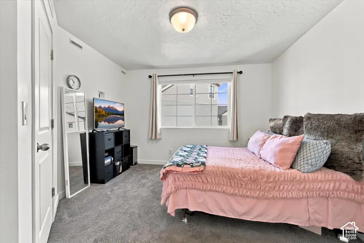 White walls, neutral carpeting, and a window with white trim