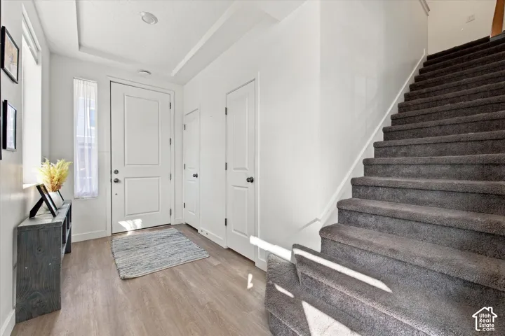 Entryway featuring light wood-finish flooring, a white paneled door, and recessed lighting