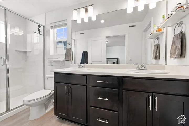 Dual vanity with dark wood-finish cabinetry, chrome hardware, and white countertops