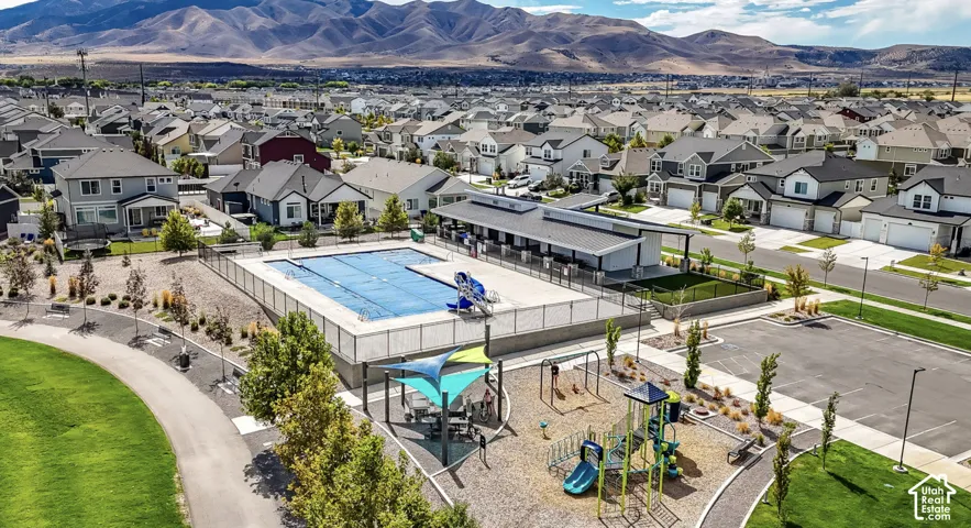Community amenities featuring an outdoor swimming pool, shaded playground area, paved walking paths, and landscaped common areas