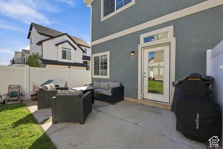 Private rear patio with concrete surfacing and an exterior light fixture