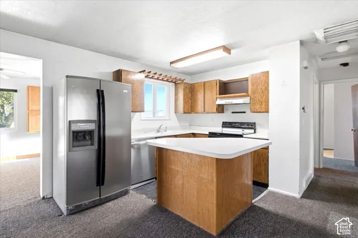 Kitchen featuring wood cabinetry, white countertops, stainless steel side-by-side refrigerator, white range, and a single window