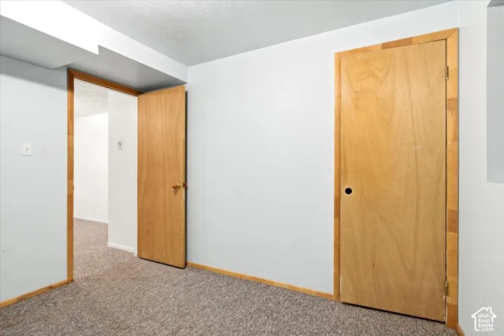 Neutral wall finishes, light wood-finish doors, and textured carpet flooring