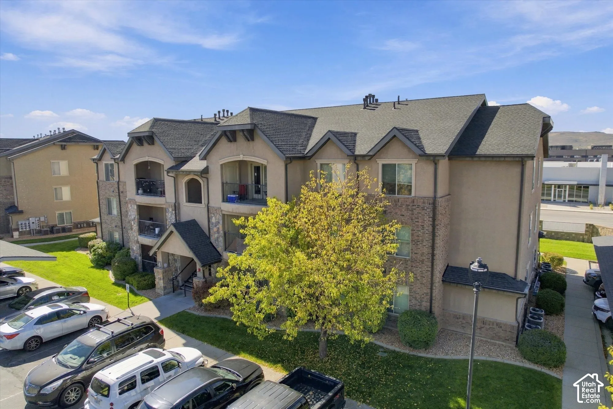 Multi-story building featuring balconies, a covered entry, and a pitched shingle roof