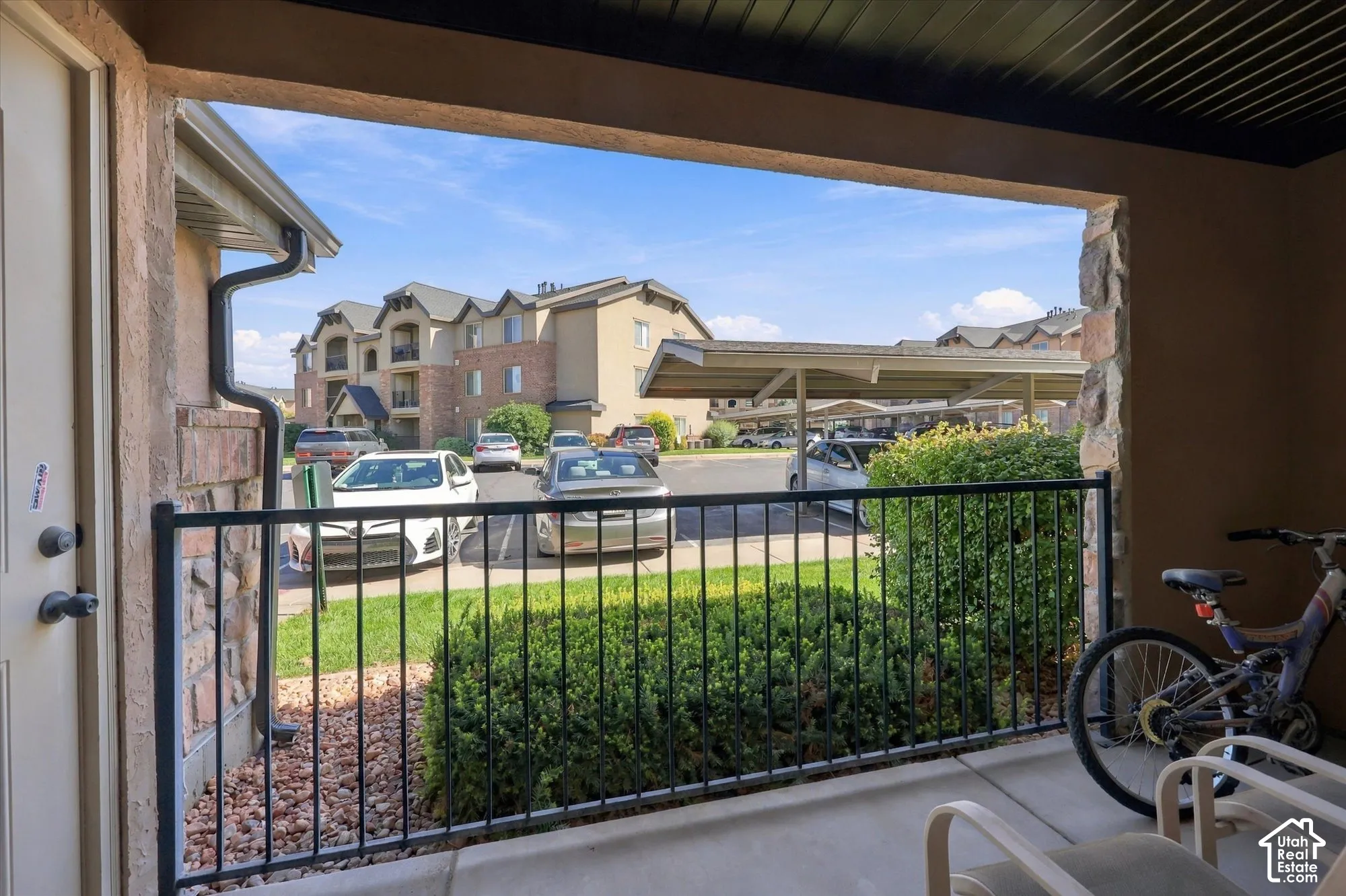 Patio featuring a black metal railing and stone-clad columns