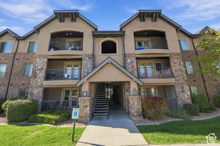 Multi-story building featuring stucco and stone veneer exterior