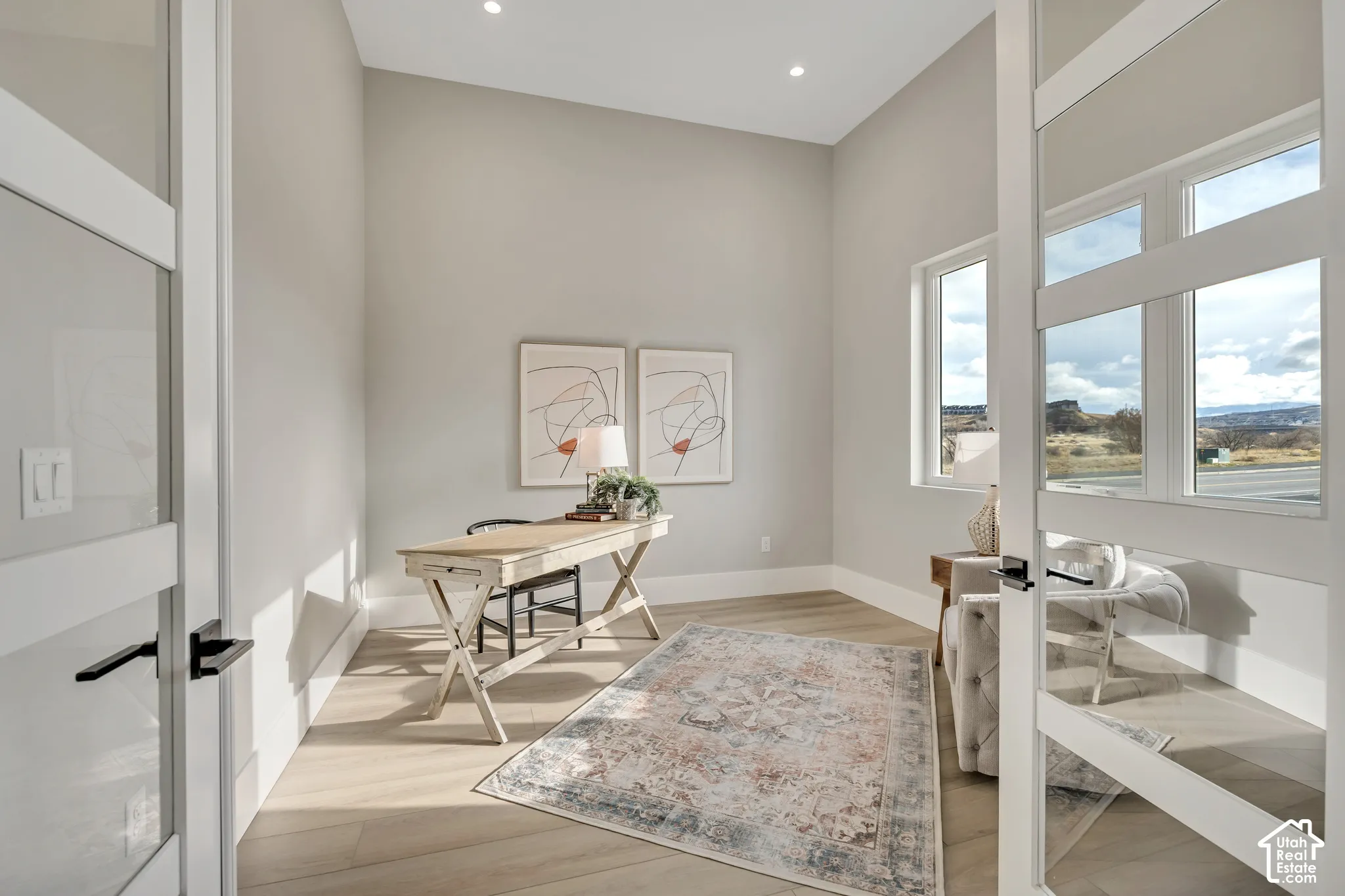 Room featuring recessed lighting, light wood-finish flooring, and multiple windows