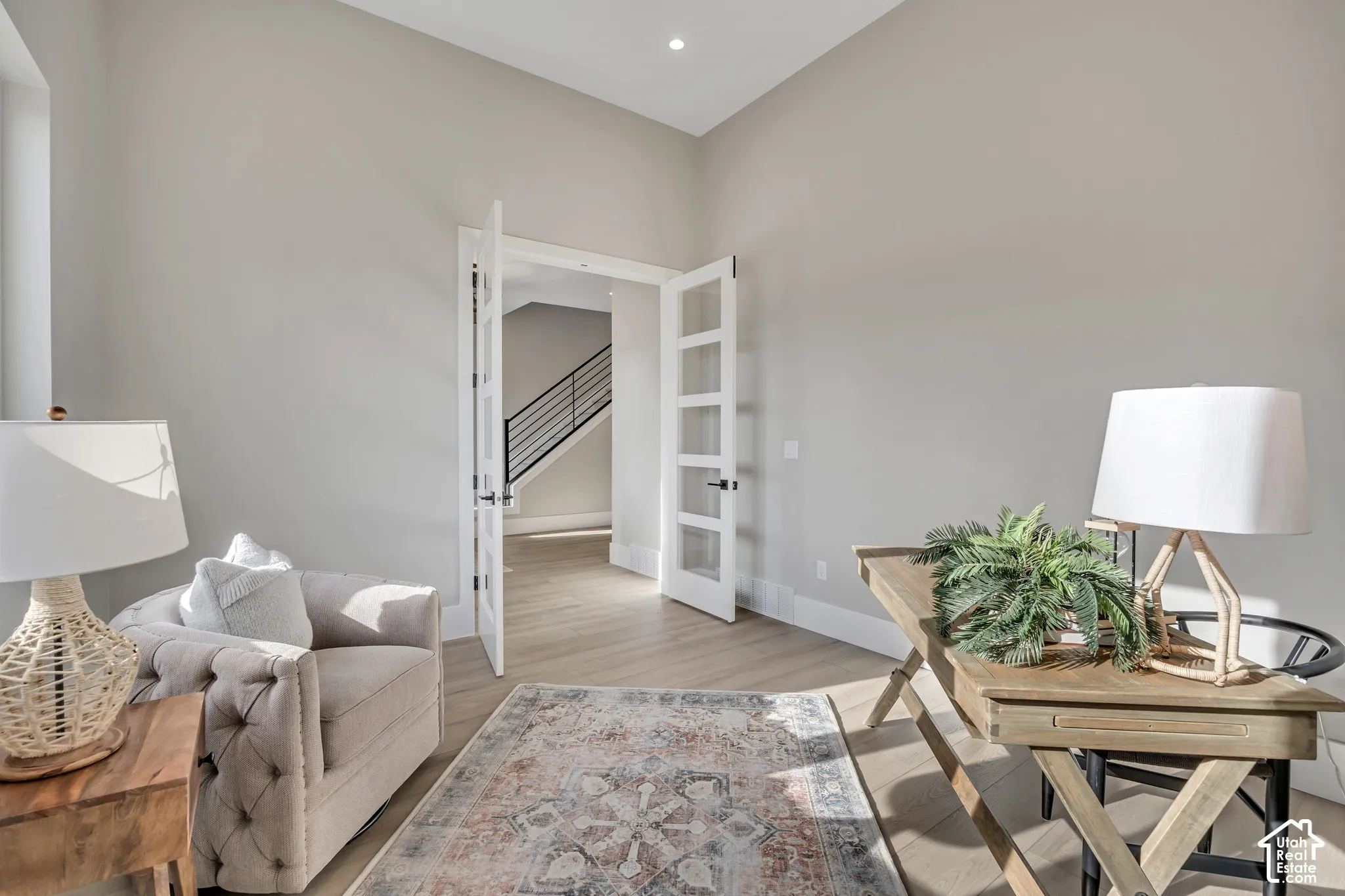 Vaulted ceiling, recessed lighting, double French doors with frosted glass, wood-finish flooring, and white trim