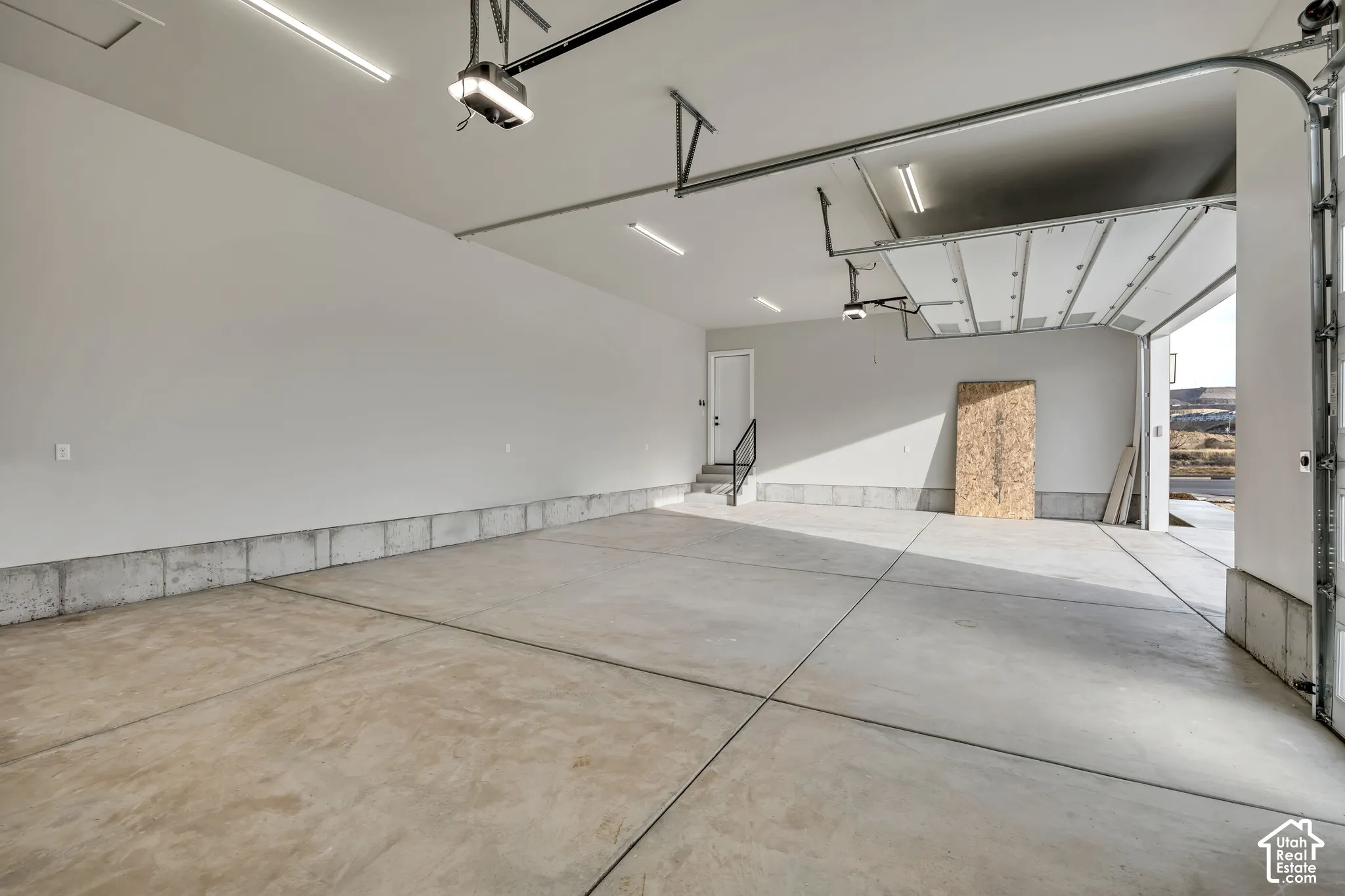 Spacious garage with concrete flooring, automatic garage door openers, and track lighting