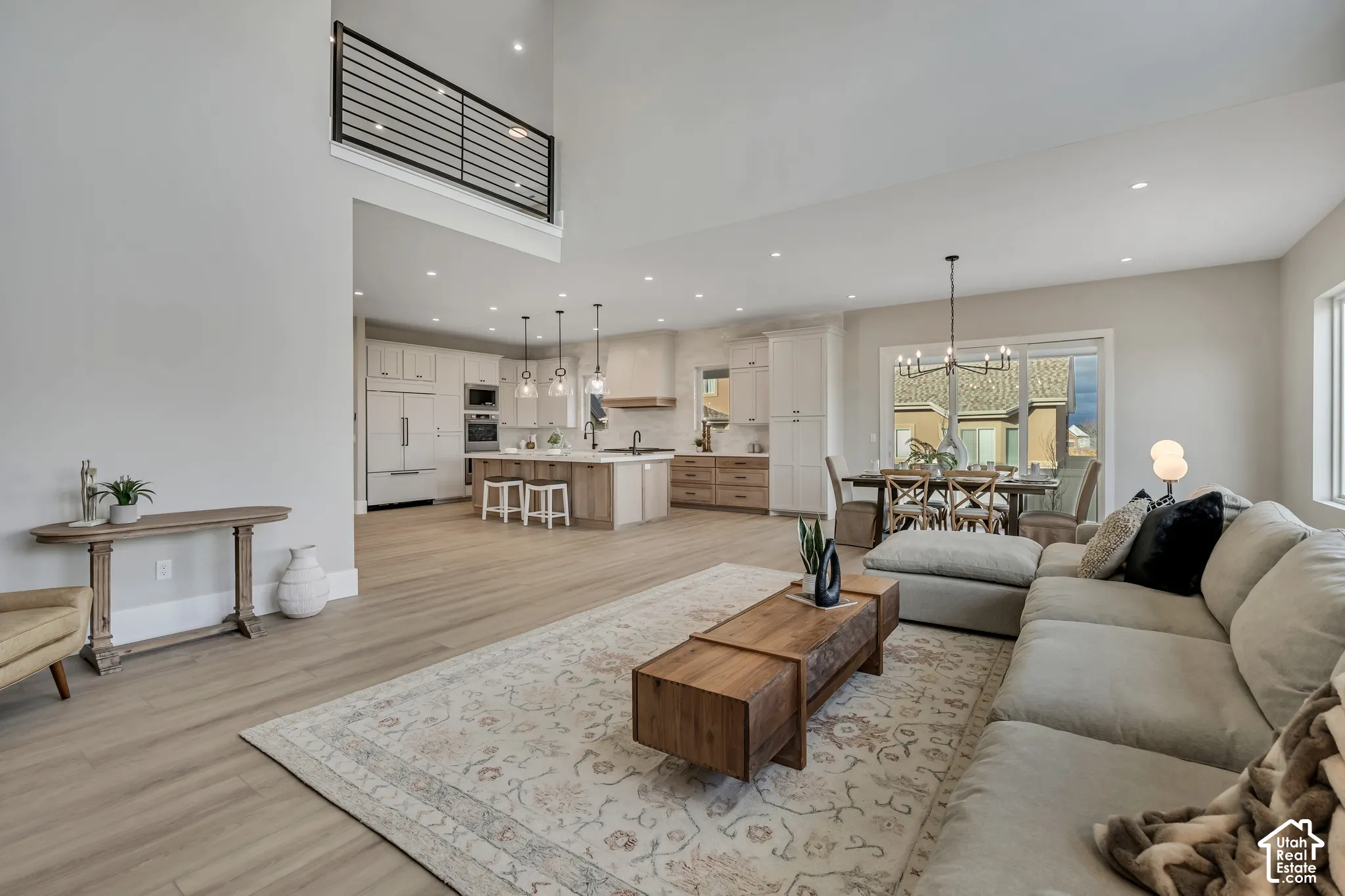 Open-concept living area featuring high ceilings, wood-finish flooring, and recessed lighting