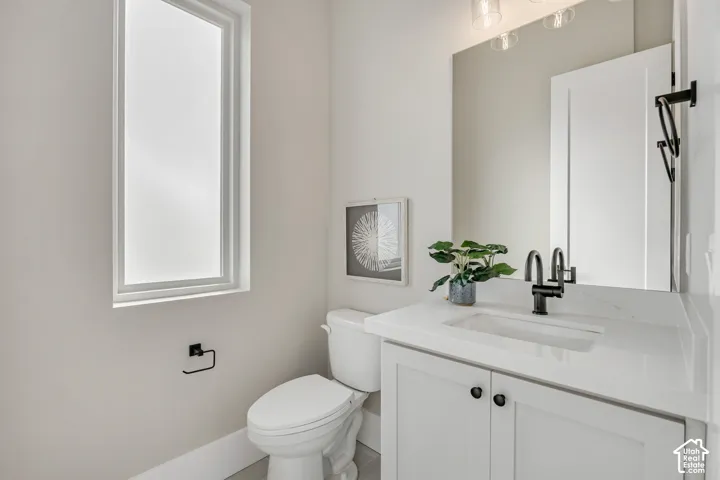 White vanity with a rectangular sink, matte black faucet, and white countertop